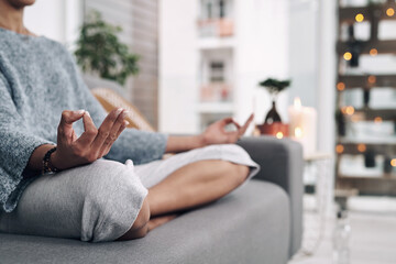 Mudra, hand and meditation on sofa in home for chakra connection, balance and mental health in morning. House, peace and zen person with spiritual healing for holistic, mindfulness and awareness