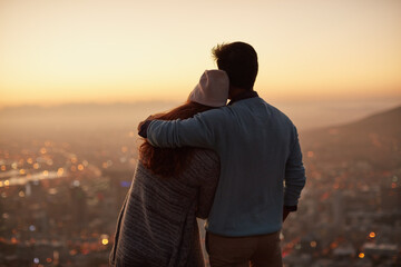 Couple, back and hug for city view at sunset, outdoor and bonding for love in relationship. People, dusk and embrace for romance on holiday or vacation, travel and relax on mountain for support