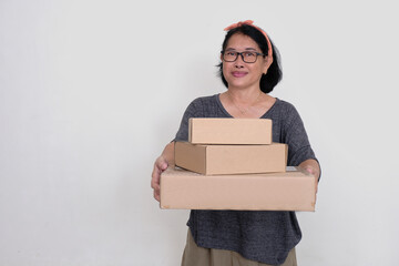 Asian woman handing over stack of carton boxes in her hands
