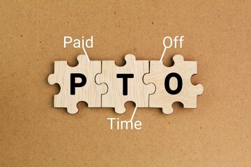 wooden puzzle with the letters PTO or the word Paid time off. According to our report, a...