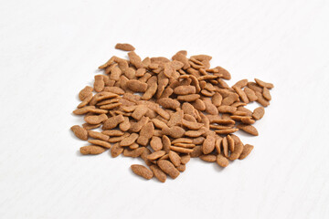 Dry cat food isolated on white background. Top view of brown kibble pieces for cat. Healthy dry pet food