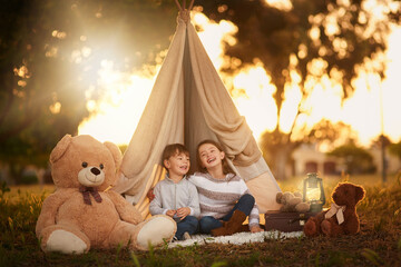 Teepee, kids and fun in garden tent outdoor in nature for camping, playing and adventure with sunlight. Cloth, happy and fantasy house for children in forest with imagination, suitcase and teddy bear © peopleimages.com