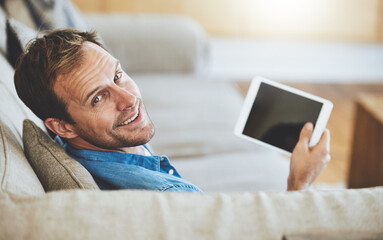 Portrait, man and happy on sofa with tablet for online movie streaming in living room with screen....
