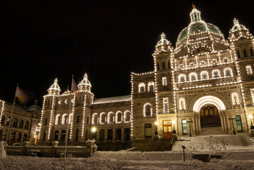 The legislature building of BC Canada lit up at night on a snowy winter evening