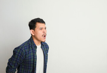 side view of young asian man with angry expression and shouting