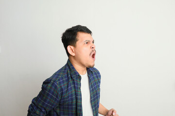 side view of young asian man with angry expression and shouting