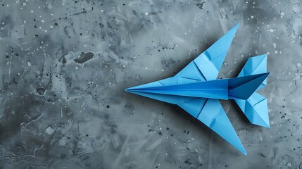 Blue airplane of origami on grey background
