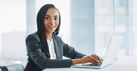 Young professional woman working in a city office, executive working on laptop.