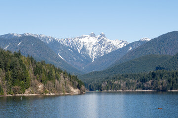 Capilano Lake Reservoir manmade lake and mountains under snow in North Vancouver Capilano River Regional Park