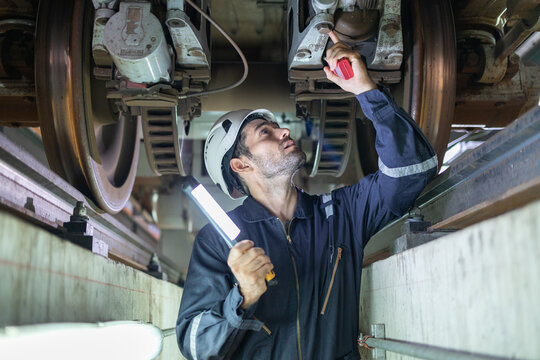 Railway technicians inspect the suspension brakes and axle stability control systems of electric locomotives to ensure they are ready for use. - Powered by Adobe