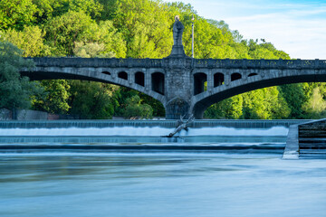 Maximiliansbrücke with statue Pallas Athene and large cascades with washed up tree trunk in the...