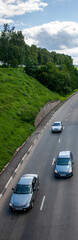Fragment of a highway with cars, top view. Three cars at a turn in the highway, from above. Fragment of a highway with cars on a summer day. 