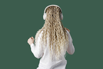Carefree woman wearing white shirt in headphones on head, listening to music, female with blonde...