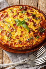 Crustless Quiche frittata with bacon, chicken and cheese closeup on the plate on the wooden table. Vertical