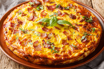 Tasty Crustless Quiche with bacon, egg, chicken and cheese closeup on the plate on the wooden table. Horizontal