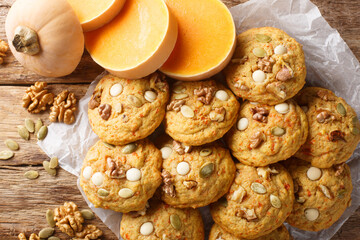 Thanksgiving pumpkin cookies with white chocolate, walnuts and seeds close-up on parchment on a...