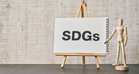 There is notebook with the word SDGs. It is an abbreviation for Sustainable Development Goals as...