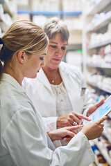 Pharmacist, women and reading together on tablet for charts, stock and analytics with sales stats....
