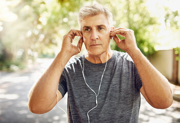 Mature man, music and headphones on street for running, fitness and exercise for wellness. Male runner, listening and audio for motivation with training, morning start to workout in New York City