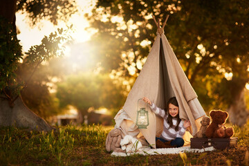 Teepee, child and fun in garden tent outdoor in nature for camping, playing and adventure with...