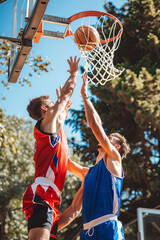 Two basketball players engaged in intense action on the court, showcasing their athletic abilities