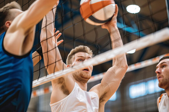 Group of male athletes intensely engaged in a competitive game of volleyball, showcasing teamwork and athleticism