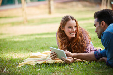 Park, picnic and happy couple relax with tablet, search or streaming social media, video or reel in...