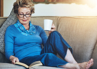 Senior woman, book and coffee with living room, sofa and relaxing for retirement rest. Lady, cup...