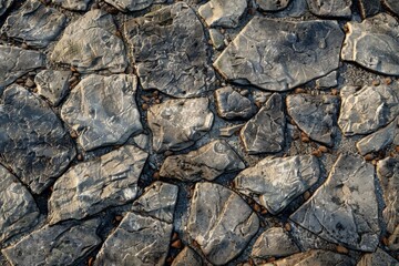 Tight shot of a grey and white natural stone wall. Rugged, aged building material pattern