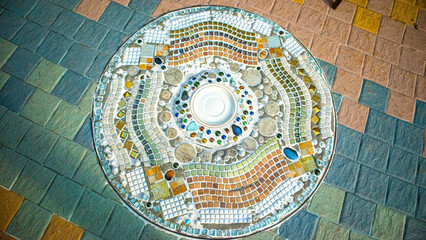 stunning mosaic artwork embedded into the floor, forming a circular pattern. It features a diverse...