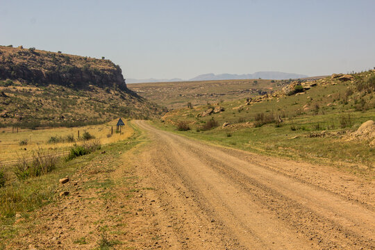 Dirt road travelling into the remote, rocky environment of the Free State Drakensberg Mountains of South Africa