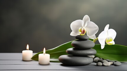 Obraz premium Zen stones, candles and white orchid flower on green and grey background
