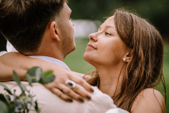 Riga, Latvia, - August 26, 2024 - Close-up of bride and groom embracing, looking at each other intimately.