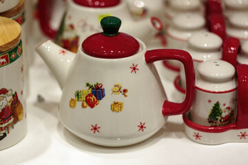 Variety of ceramic teapots and containers, all adorned with festive designs.