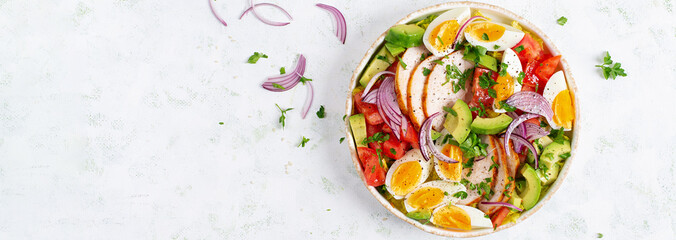 Healthy cobb salad with chicken, avocado, tomato, red onions and eggs. American food. Top view, banner