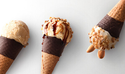 Detail of three ice cream cones of various on white
