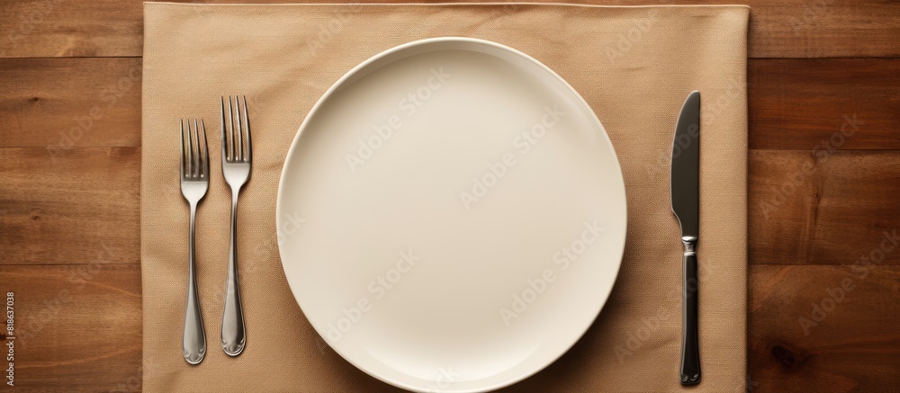 Poster A top view of a table setting with an empty plate a knife a fork and a napkin providing ample copy space for customization