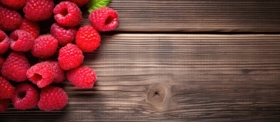 A copy space image showcasing fresh raspberries displayed on a rustic wooden backdrop