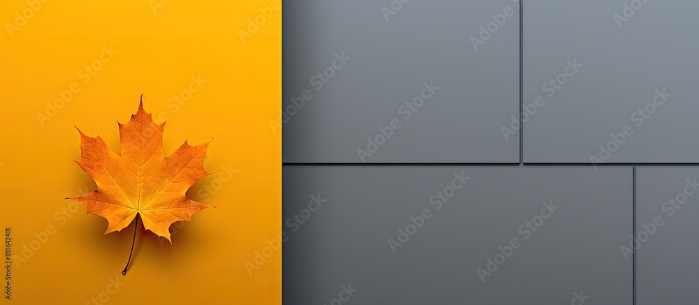 Poster a yellow and grey geometric background with a single orange fallen maple leaf providing ample copy s