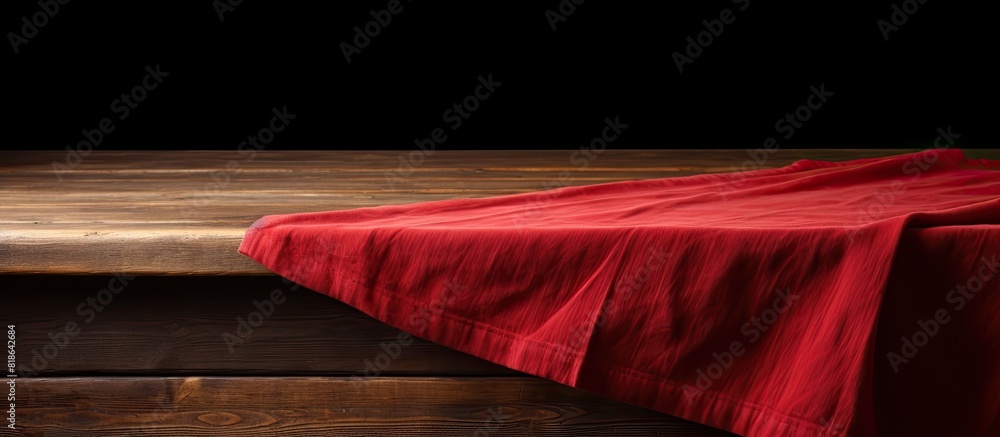Poster a brown wooden table with a red tablecloth or towel covering its surface creating copy space image