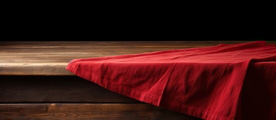 A brown wooden table with a red tablecloth or towel covering its surface creating copy space image