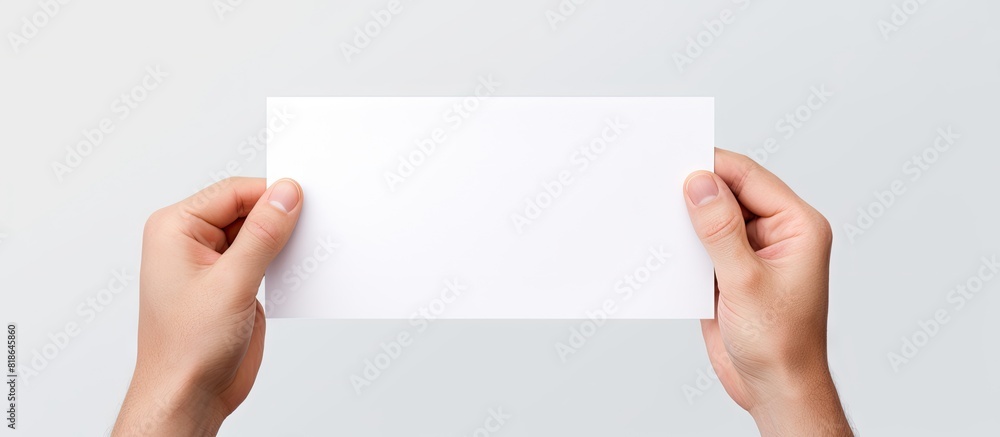 Poster a hand is holding a white piece of paper isolated on a white background with ample copy space for th