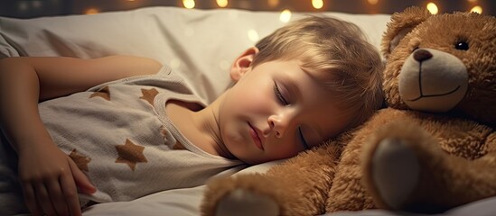 Adorable kid boy peacefully sleeping on a bed with his favorite teddy bear creating a heartwarming copy space image