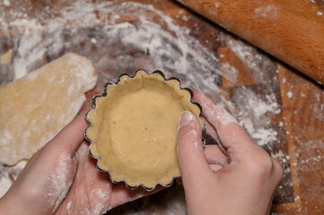 Tartaletki babeczki z kruchego ciasta podczas szykowania spodów do napełniania 