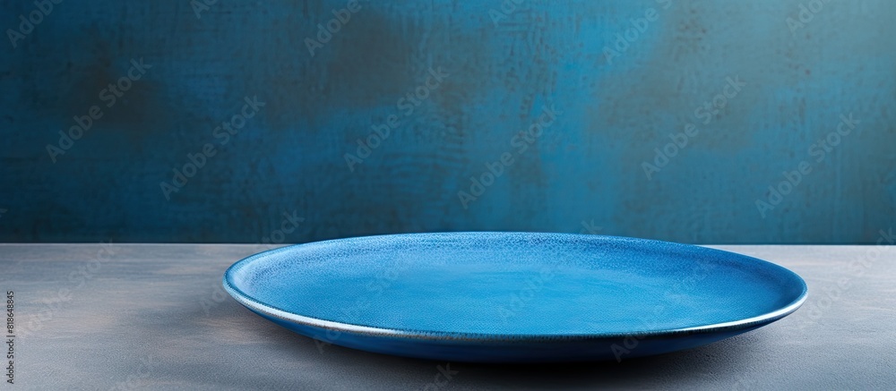 Poster A perspective view of a blue plate on a cement background with empty space for your design presented as a copy space image