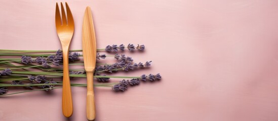 Organic wooden cutlery includes a fork and takeaway knife resting on a lavender background...