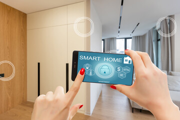 Close up smartphone in female hand with smart home system app interface on cellphone screen, young woman controlling all house system by phone in modern apartment, internet of things concept.