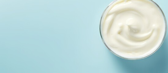 A delicious organic yogurt is displayed on a light blue surface with a top down perspective...