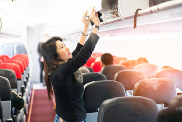 People traveler and tourism woman open overhead locker on airplane.Traveling and Business concept