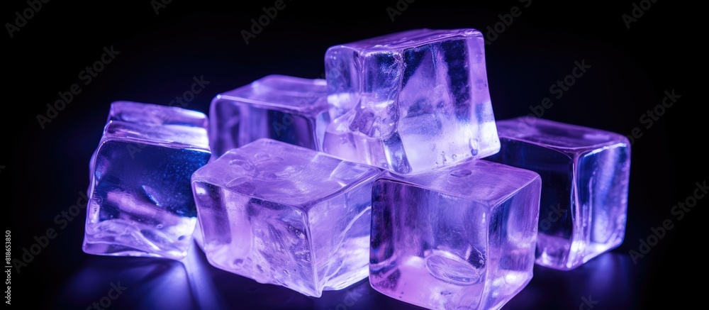 Poster Isolated on a black background there is a copy space image of transparent ice cubes illuminated by a soft purple light